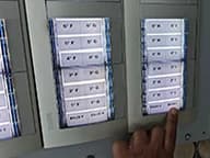 El panel de telefonillos del portal, con una mano pulsando el del Bajo 1.